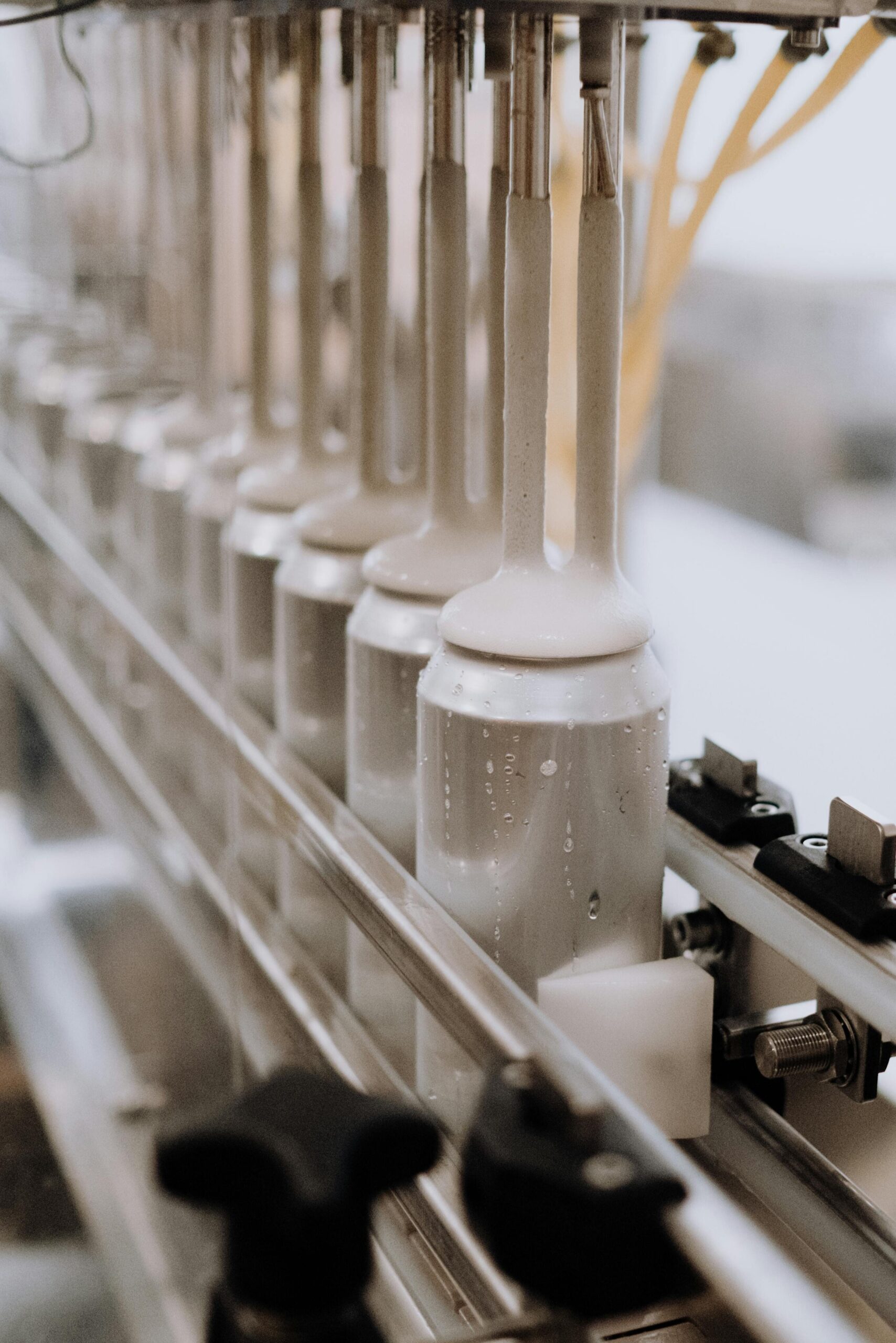 Close-up of automated canning equipment in a brewery, highlighting the manufacturing process.